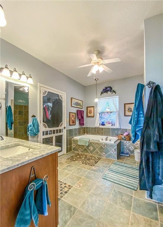 full bathroom featuring vanity, a garden tub, and a ceiling fan