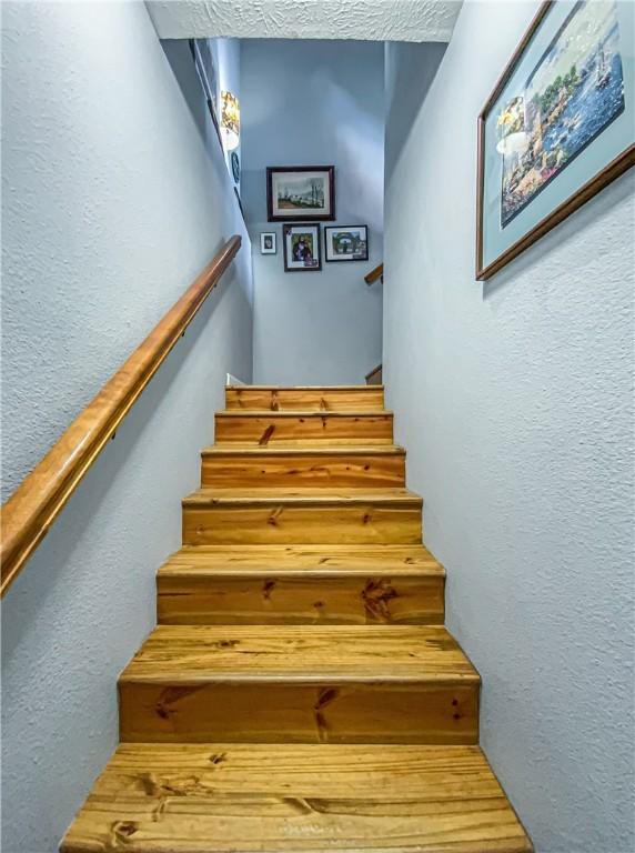 stairs featuring a textured wall