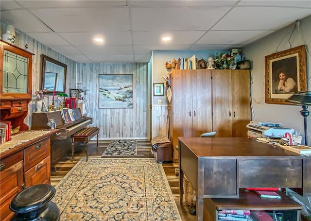 home office with a drop ceiling and wood finished floors