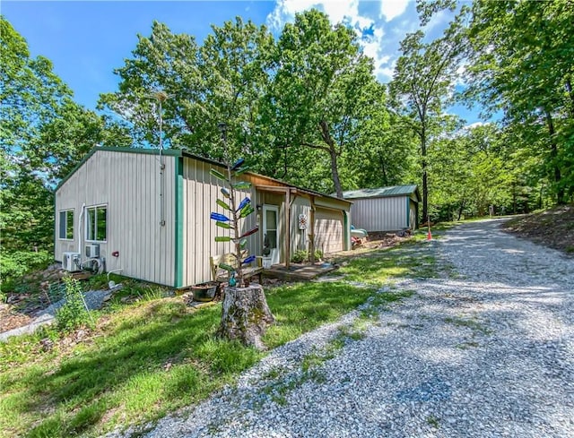 view of side of property with driveway and an outbuilding