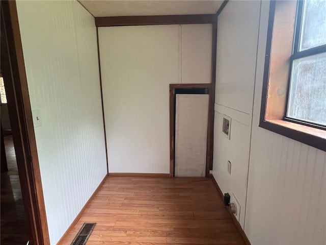 unfurnished room featuring light wood-style floors, a healthy amount of sunlight, and visible vents