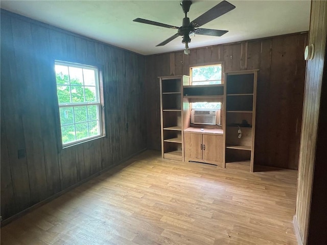 interior space featuring wood walls, cooling unit, and light wood-style floors