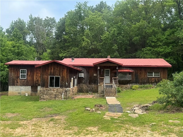 view of front facade featuring metal roof and a front lawn
