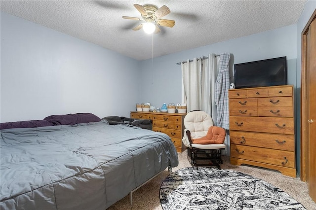 carpeted bedroom featuring a textured ceiling and a ceiling fan