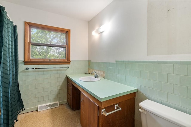5 College St, Eureka Springs, AR 72632 - bathroom featuring tile walls, toilet, vanity, wainscoting, and a shower with curtain