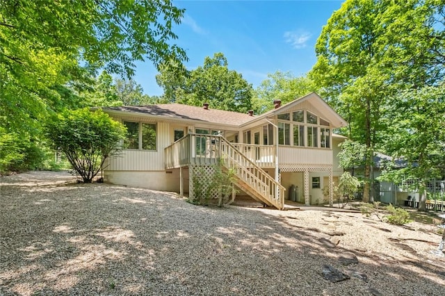 4 Tisbury Ln, Bella Vista, AR 72715 - rear view of house featuring stairway, a wooden deck, a sunroom, and a chimney