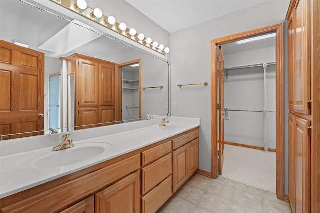 4 Tisbury Ln, Bella Vista, AR 72715 - bathroom with double vanity, a walk in closet, and baseboards
