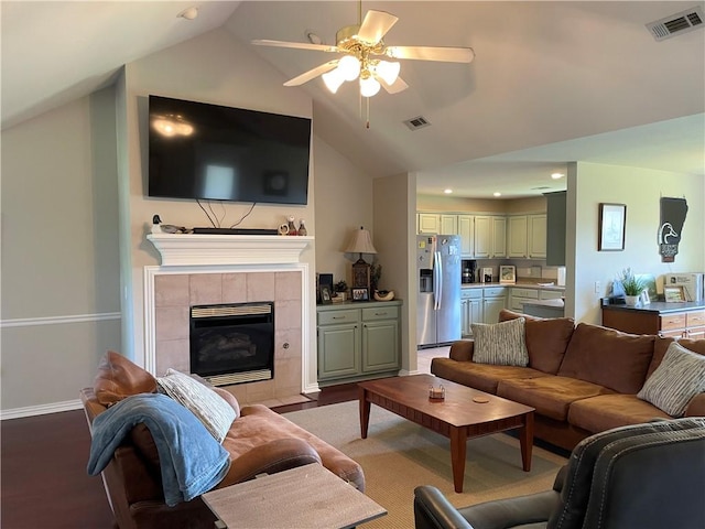 814 Irelan St, Lowell, AR 72745 - living area featuring vaulted ceiling, a tile fireplace, visible vents, and ceiling fan