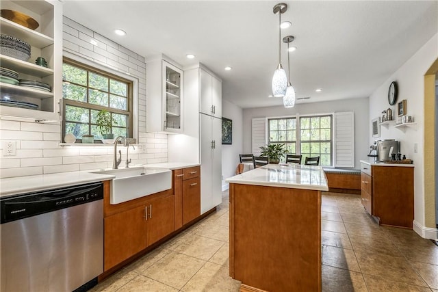 8 Eddy Ln, Bella Vista, AR 72715 - kitchen featuring stainless steel dishwasher, a sink, a kitchen island, decorative backsplash, and light countertops