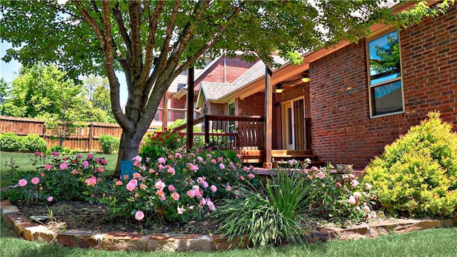 view of yard with fence, a deck, and ceiling fan