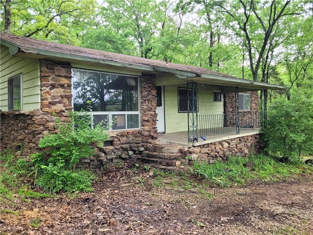 view of front of house featuring covered porch and stone siding