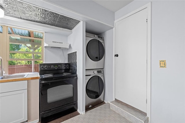 laundry area featuring stacked washer and clothes dryer and a sink