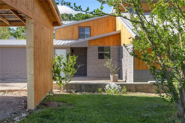 view of side of home with a lawn, metal roof, and a standing seam roof