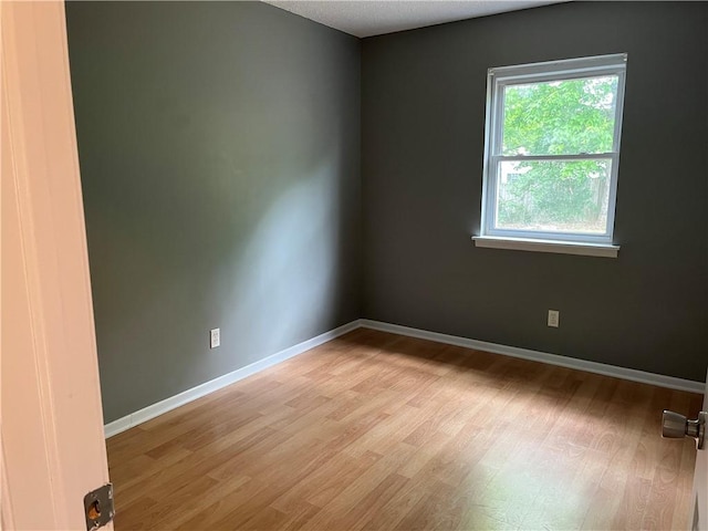 unfurnished room featuring light wood finished floors and baseboards