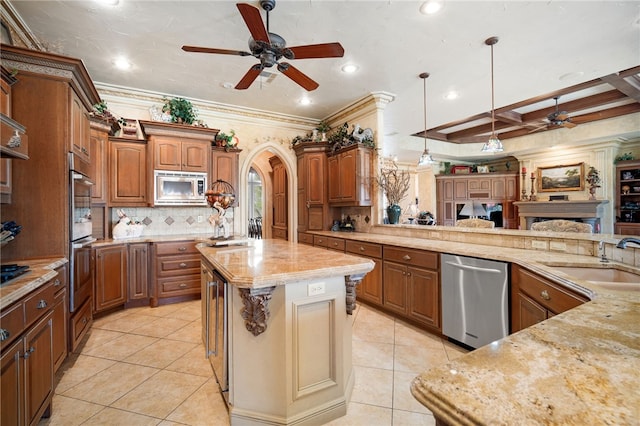 kitchen featuring light tile patterned floors, a sink, stainless steel appliances, open floor plan, and ceiling fan