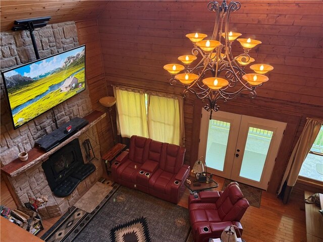 2132 County Road 246, Berryville, AR 72616 - living area featuring french doors, wood walls, a chandelier, hardwood / wood-style flooring, and a wood stove