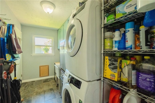 314 Crestview Dr, Bentonville, AR 72712 - laundry area with stacked washer and clothes dryer, baseboards, and stone finish floors