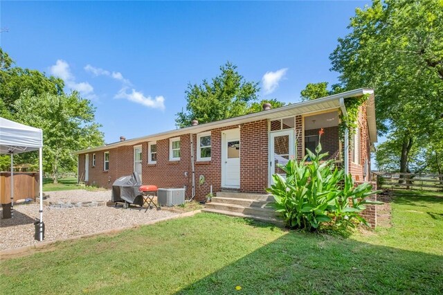 101 Carter Ln, Elkins, AR 72727 - rear view of house featuring fence, brick siding, central AC, a yard, and entry steps
