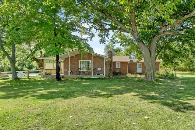 101 Carter Ln, Elkins, AR 72727 - back of property featuring brick siding, fence, a chimney, and a lawn