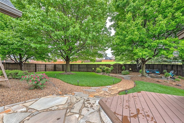 view of yard featuring a patio area, a deck, and a fenced backyard