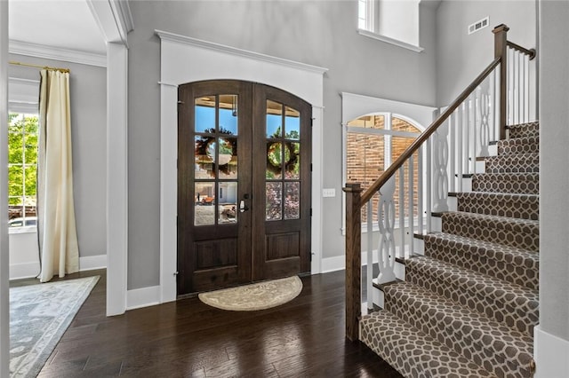 entryway featuring baseboards, hardwood / wood-style floors, french doors, ornamental molding, and stairway