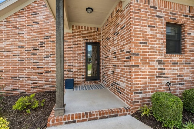 doorway to property featuring brick siding