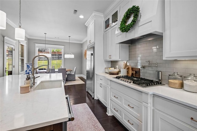 kitchen featuring a sink, stainless steel appliances, white cabinetry, dark wood-style flooring, and tasteful backsplash
