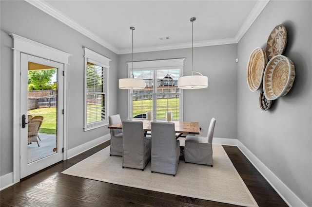 dining space featuring dark wood-style floors, baseboards, and crown molding