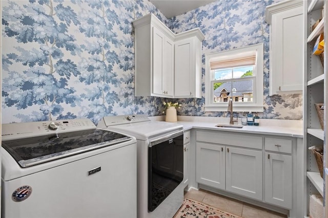 washroom with wallpapered walls, washing machine and clothes dryer, light tile patterned floors, and cabinet space
