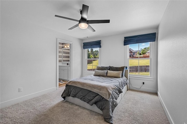 carpeted bedroom featuring baseboards, a ceiling fan, and ensuite bathroom