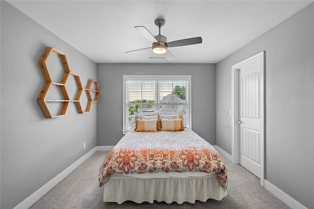 bedroom with light colored carpet, baseboards, and ceiling fan