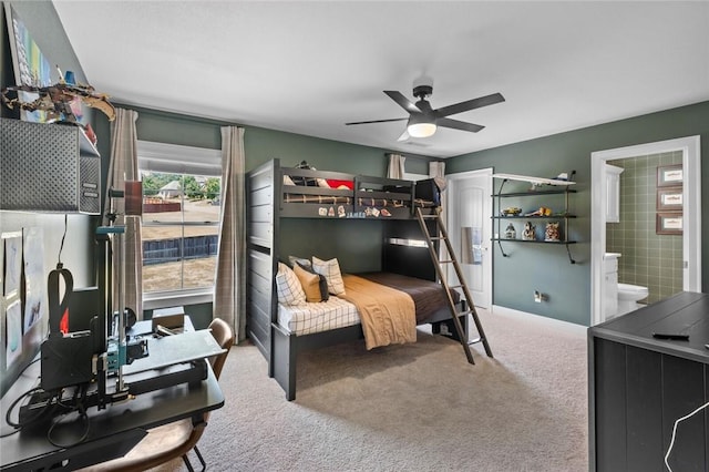 carpeted bedroom with connected bathroom, baseboards, and ceiling fan