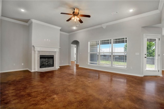 unfurnished living room with finished concrete flooring, a ceiling fan, arched walkways, baseboards, and a tile fireplace