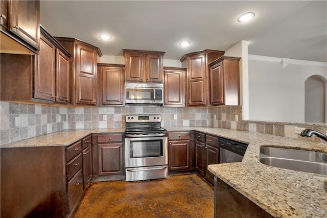 kitchen with stainless steel appliances, a sink, ornamental molding, light stone counters, and decorative backsplash