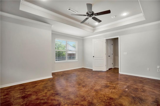 unfurnished room with concrete flooring, a tray ceiling, a ceiling fan, baseboards, and ornamental molding