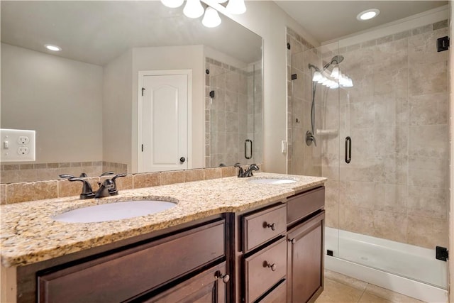 bathroom with a shower stall, double vanity, tile patterned floors, and recessed lighting
