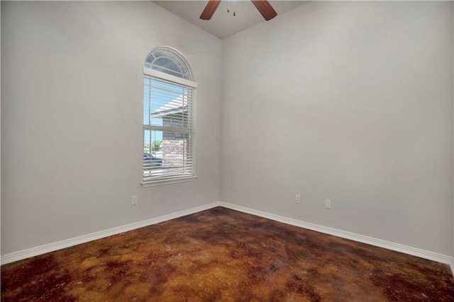 unfurnished room featuring concrete flooring, ceiling fan, vaulted ceiling, and baseboards