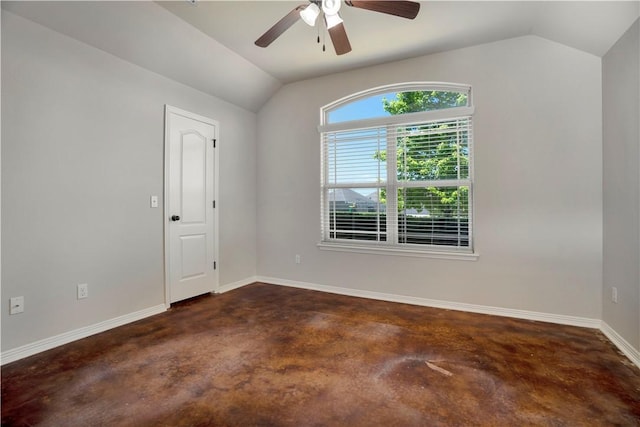 empty room featuring concrete floors, vaulted ceiling, a ceiling fan, and baseboards