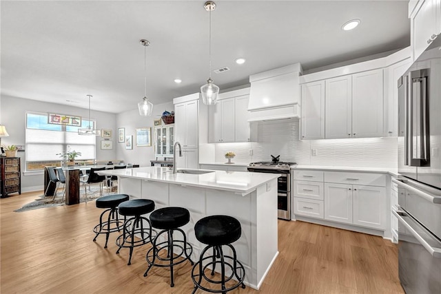 2227 Riggins Ave, Pea Ridge, AR 72751 - kitchen with appliances with stainless steel finishes, a breakfast bar area, a sink, an island with sink, and light countertops