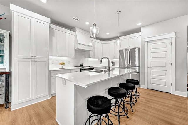 2227 Riggins Ave, Pea Ridge, AR 72751 - kitchen with a sink, custom exhaust hood, light wood-type flooring, white cabinets, and recessed lighting