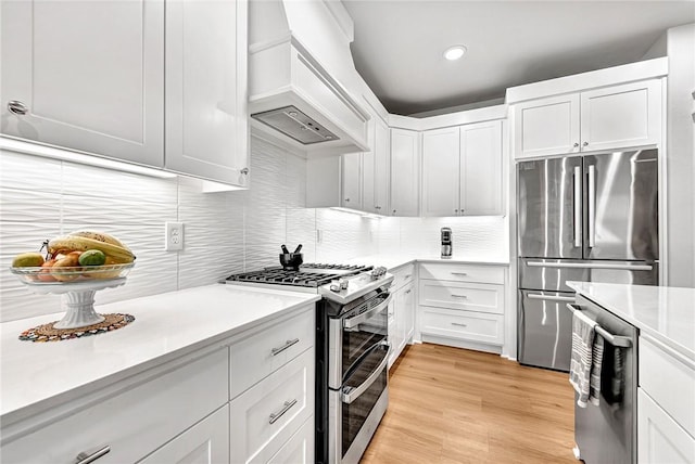 2227 Riggins Ave, Pea Ridge, AR 72751 - kitchen with stainless steel appliances, custom range hood, light countertops, white cabinets, and recessed lighting