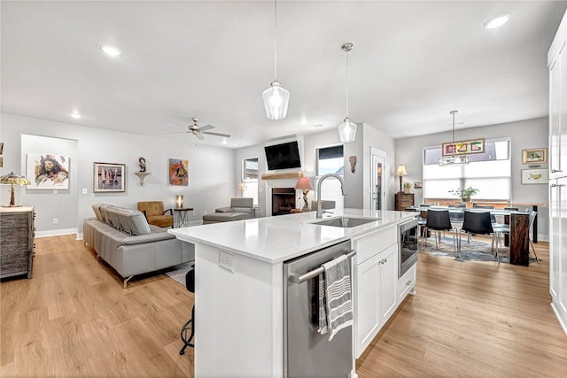 2227 Riggins Ave, Pea Ridge, AR 72751 - kitchen with a sink, appliances with stainless steel finishes, a fireplace, white cabinets, and a center island with sink