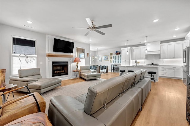 2227 Riggins Ave, Pea Ridge, AR 72751 - living room featuring light wood-style floors, ceiling fan, a fireplace, and recessed lighting