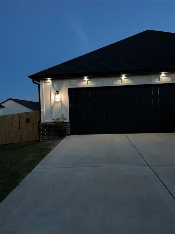2227 Riggins Ave, Pea Ridge, AR 72751 - garage at twilight featuring concrete driveway