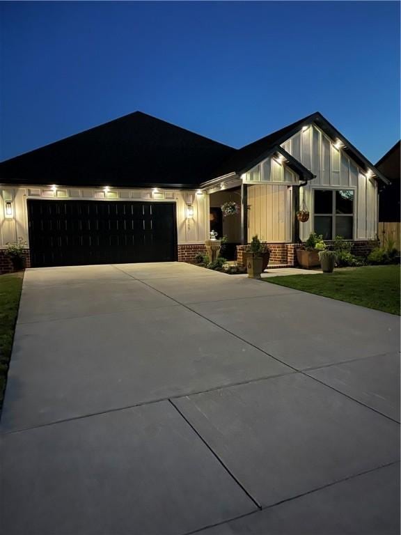 2227 Riggins Ave, Pea Ridge, AR 72751 - view of front of property with brick siding, board and batten siding, an attached garage, and driveway