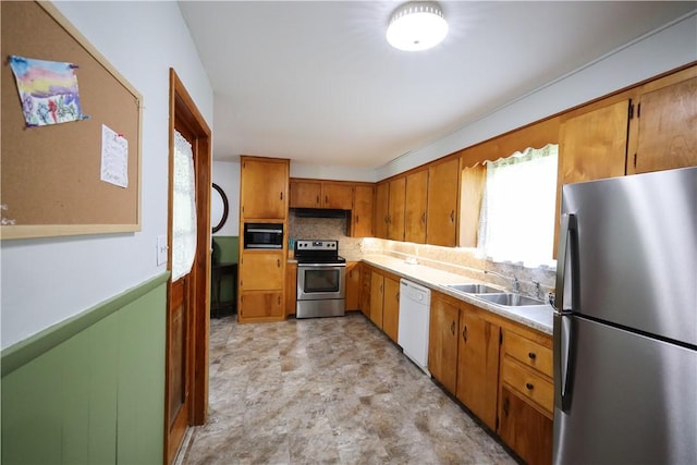 910 Sunset Ln, Harrison, AR 72601 - kitchen with stainless steel appliances, a sink, brown cabinetry, and healthy amount of natural light