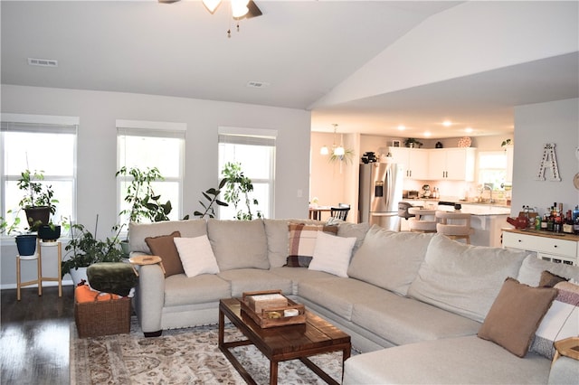 living room with lofted ceiling, wood finished floors, a ceiling fan, and a chandelier