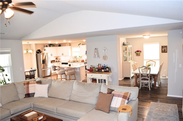 living room featuring lofted ceiling, dark wood-style floors, ceiling fan, and healthy amount of natural light