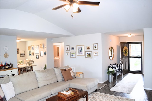 living room featuring dark wood-style floors, vaulted ceiling, a ceiling fan, and baseboards