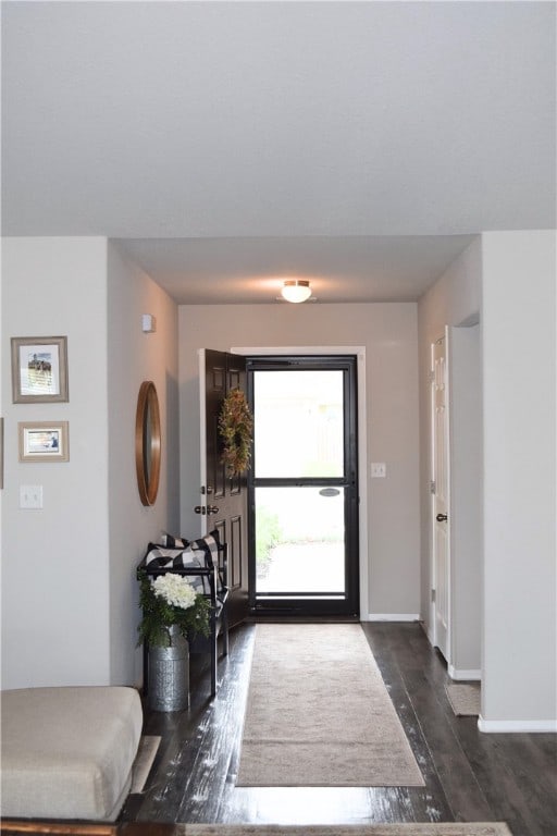 foyer entrance with dark wood-type flooring and baseboards